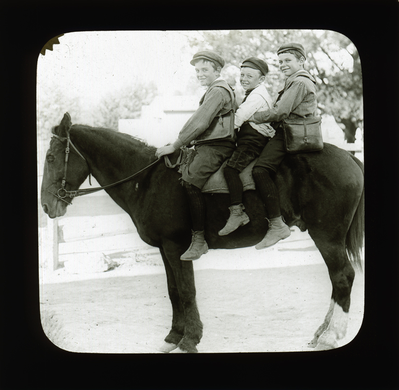 Three boys with school satchels on horseback [Hawkesbury Agricultural College (HAC)]