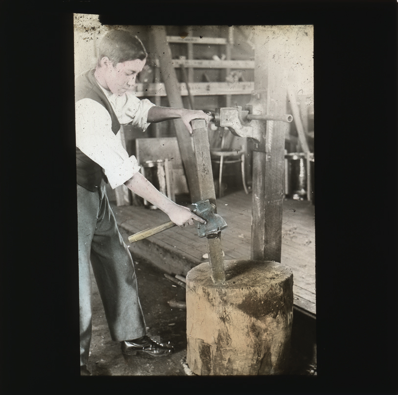 Student preparing timber with a carpenters axe [Hawkesbury Agricultural College (HAC)]
