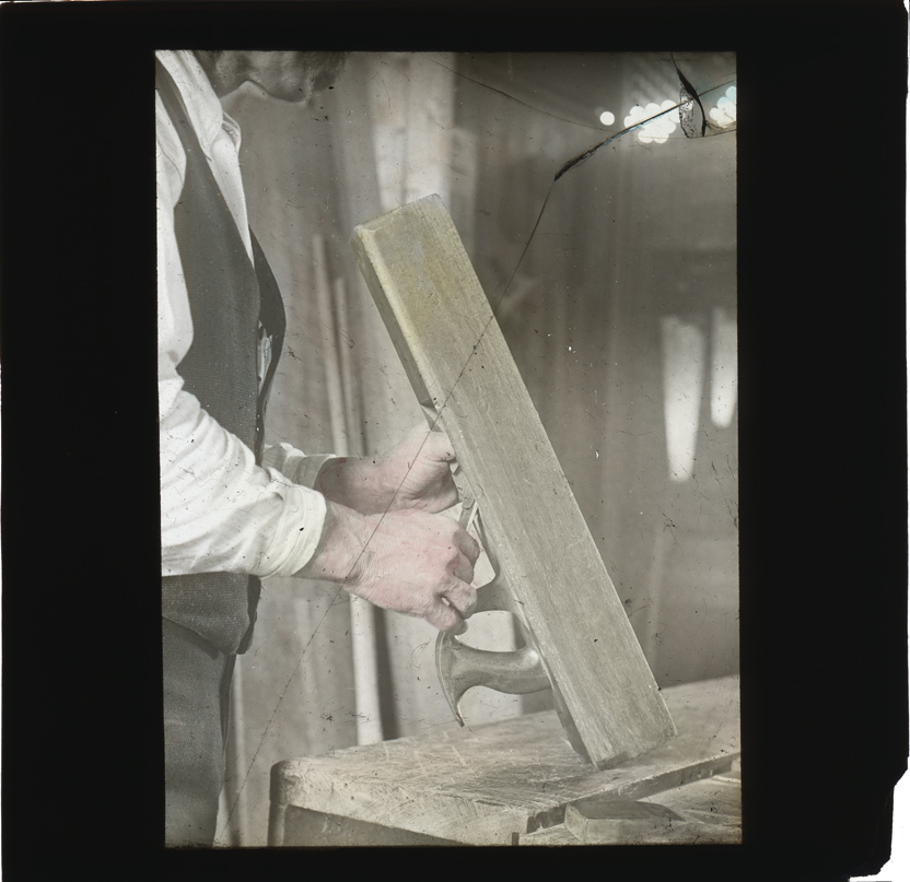 Man examining a wooden hand plane [Hawkesbury Agricultural College (HAC)]