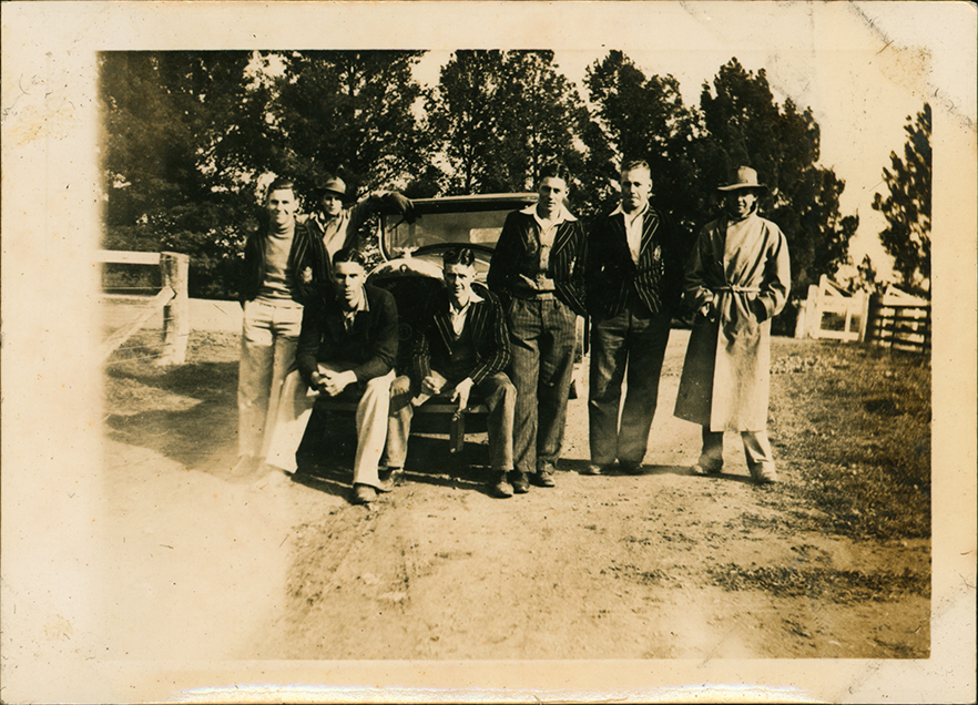 Students standing around a car (most in blood and mustard blazers)