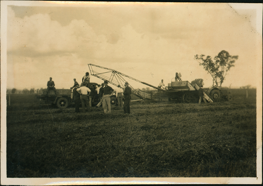 Students inspecting a Case hay bailer pulled by a tractor