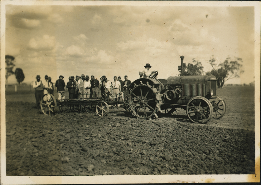 Students inspecting a tractor in a field