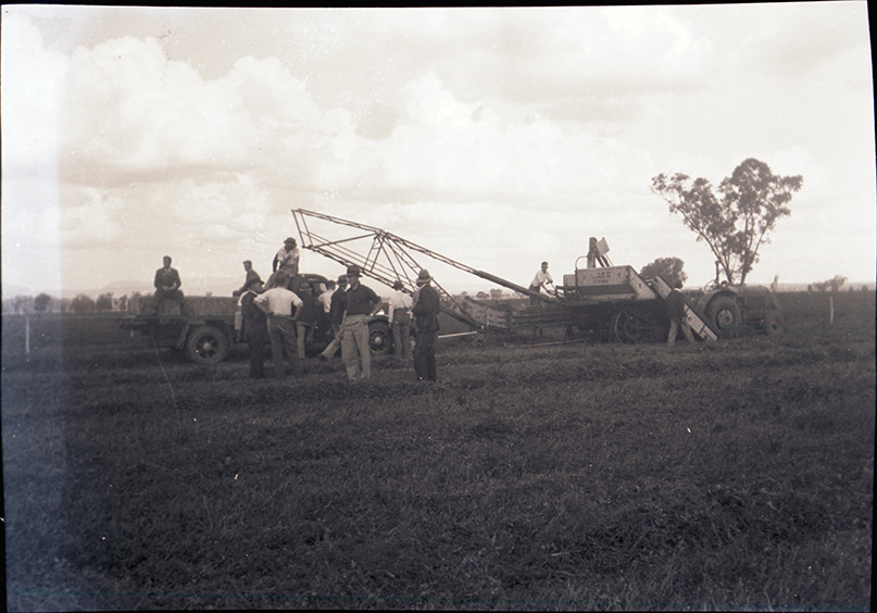 Students inspecting a Case hay bailer pulled by a tractor