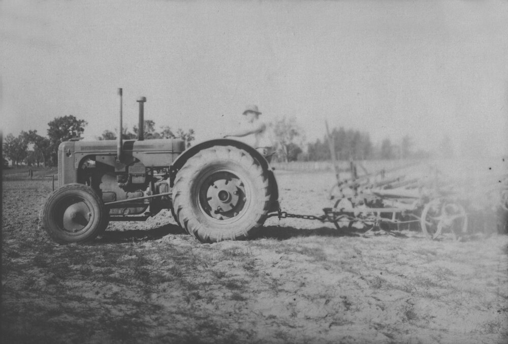 A tractor, driven by a student, towing farm machinery [Hawkesbury Agricultural College (HAC)]