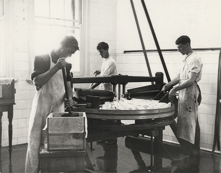 Three students using a butter working table [Hawkesbury Agricultural College (HAC)]