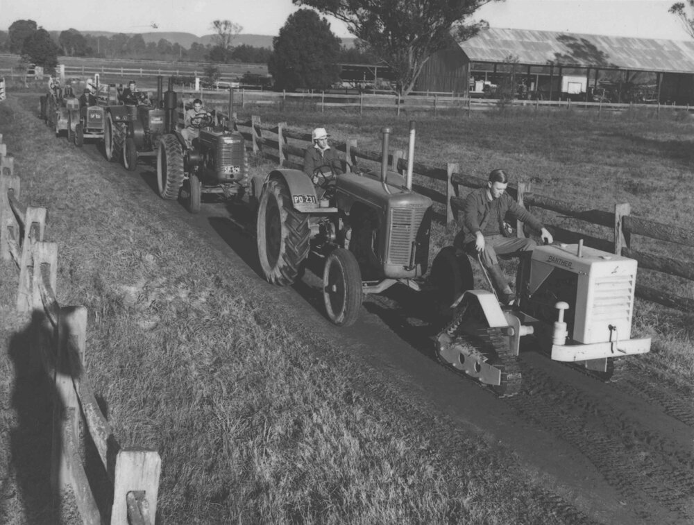 Tractors (7) assembled in a tractor parade along a dirt road [Hawkesbury Agricultural College (HAC)]