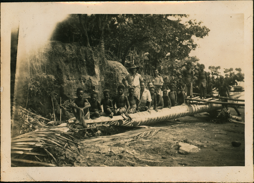 Large canoe full of people pulled up on the beach - Cassia Village (near Hoskins Airfield, New Britain Island, Papua New Guinea)