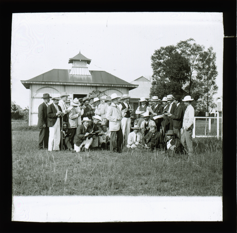 Charles Musson &amp; class in a paddock, unidentified building in background [Hawkesbury Agricultural College (HAC)]
