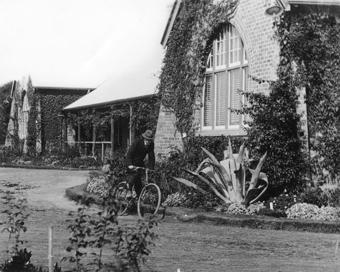 Main Administration Building - A man riding a bicycle past [Hawkesbury Agricultural College (HAC)]