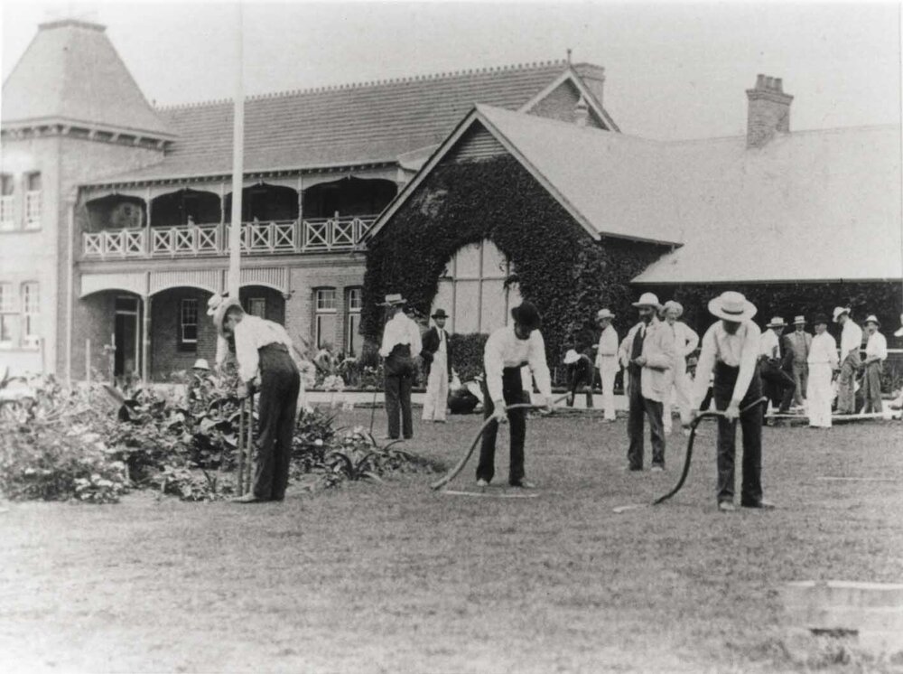 Students scything front lawn under instruction [Hawkesbury Agricultural College (HAC)] - Print 2 of 2 - Cropped
