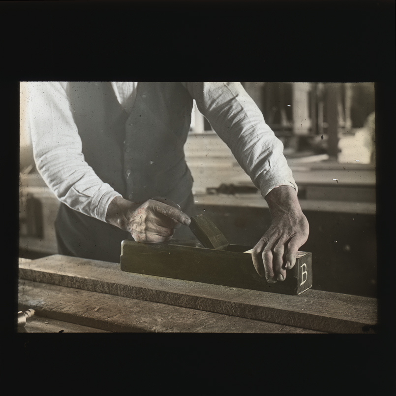 Woodworking - hands holding and using a wooden hand block plane [Hawkesbury Agricultural College (HAC)]