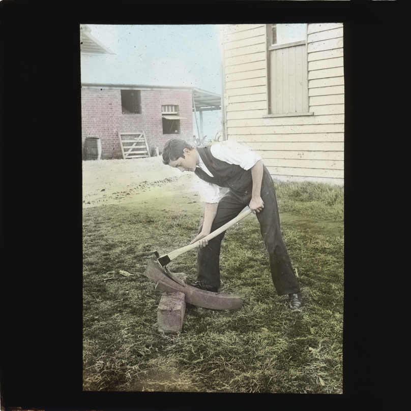 Student shaping timber using an adze [Hawkesbury Agricultural College (HAC)]