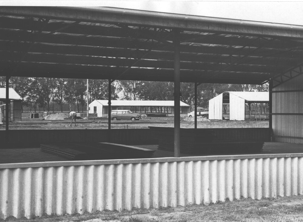 A view through newly constructed poultry sheds at a man working on the site [Hawkesbury Agricultural College (HAC)]