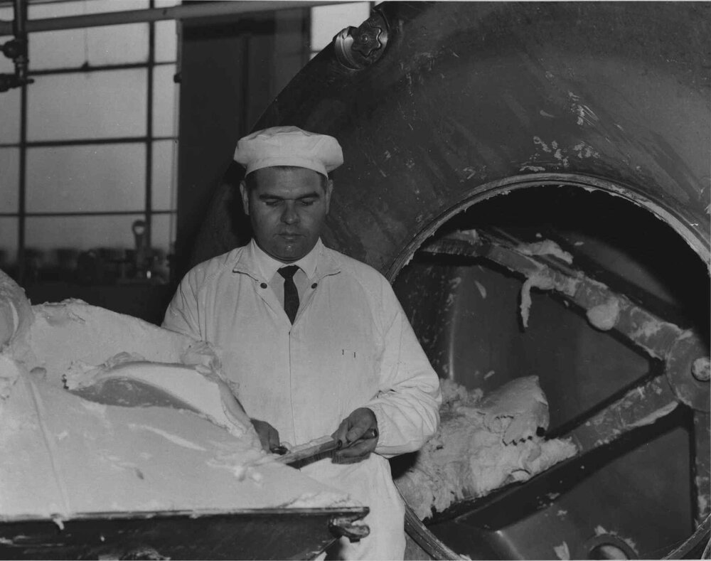 John Davis, instructor in butter making and ice-cream, standing by the machinery in the Dairy Factory [Hawkesbury Agricultural College (HAC)]