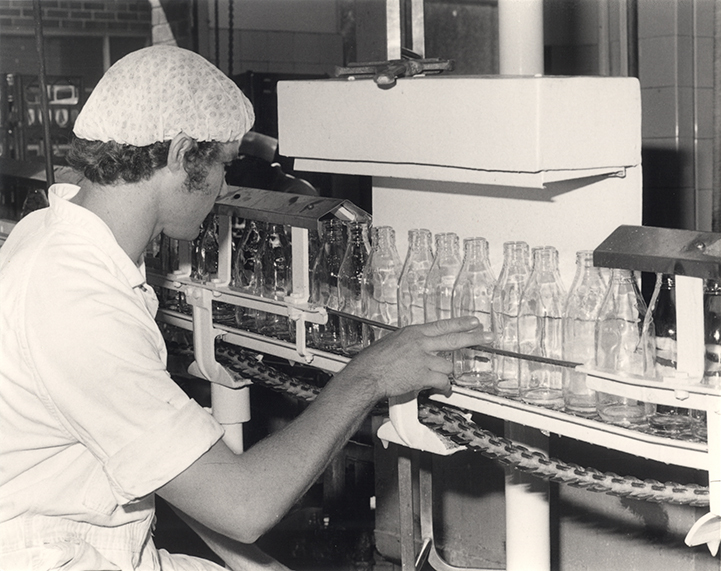 Dairy Factory (interior): student checking clean milk bottles (Print 1 of 2) [Hawkesbury Agricultural College (HAC)]