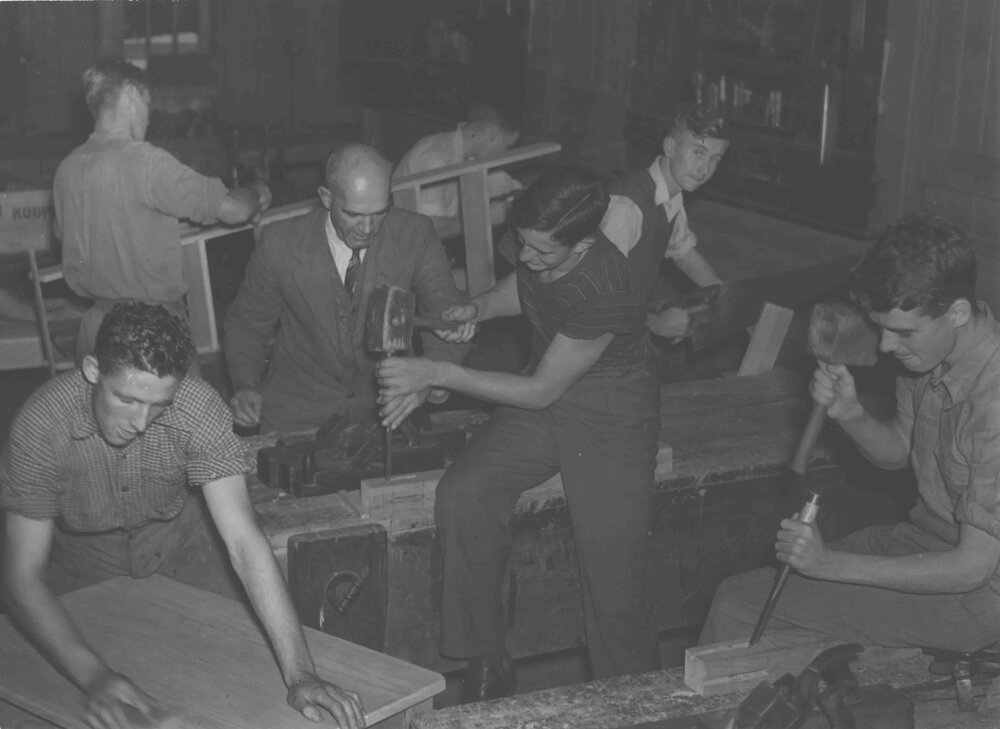 Students working at carpentry benches under supervision of staff member [Hawkesbury Agricultural College (HAC)]