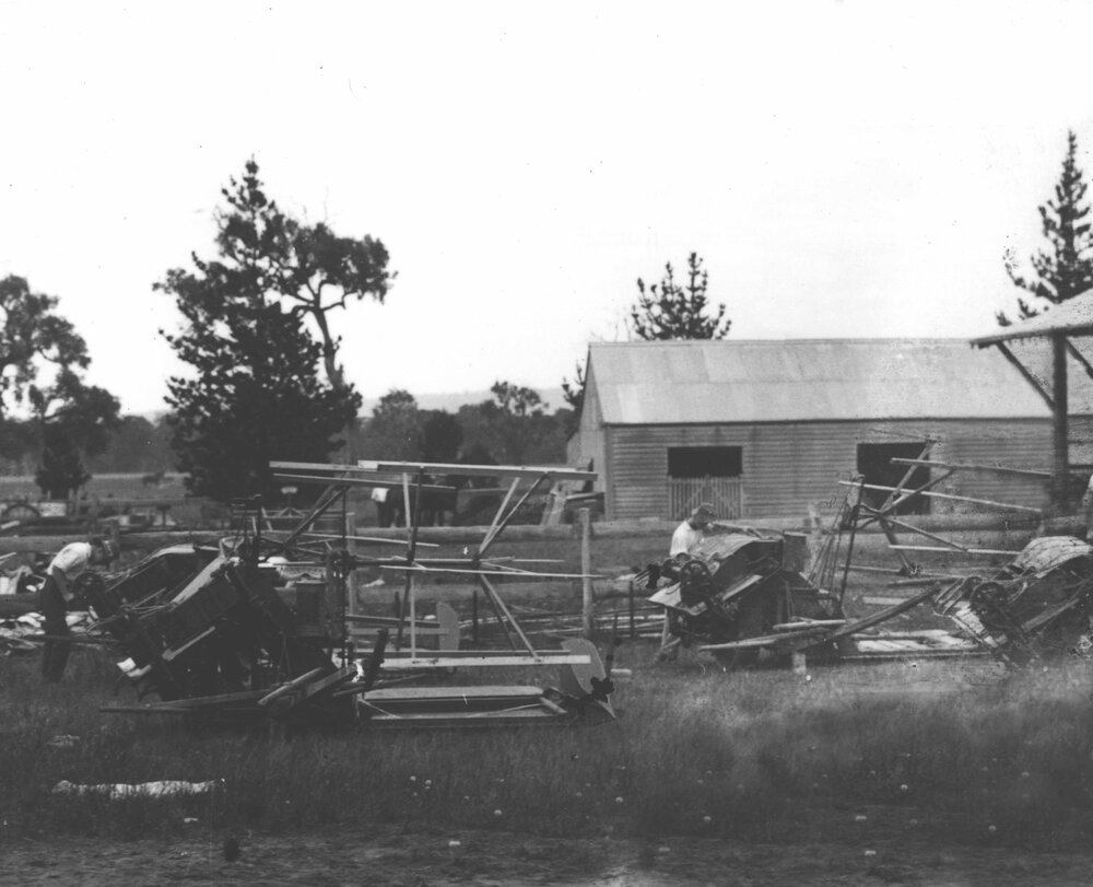 Students working on reapers and binders outside sheds [Hawkesbury Agricultural College (HAC)]