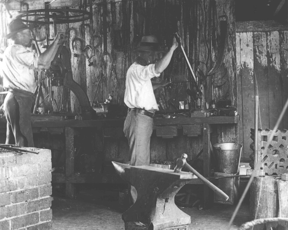 Blacksmith Shop (interior) - Two men working at a bench [Hawkesbury Agricultural College (HAC)]