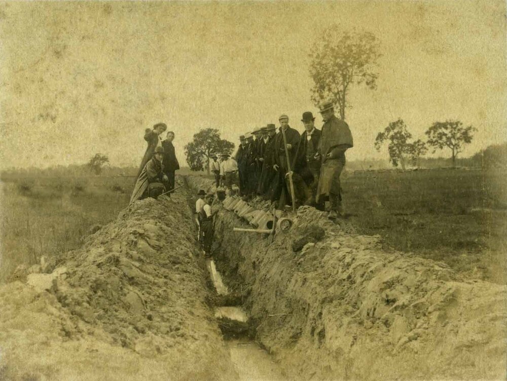 Draining the Orchard, 1892' - two men standing in trough, pipes, others standing on sides of trough, not workers - Uncropped (Print 1 of 2) [Hawkesbury Agricultural College (HAC)]