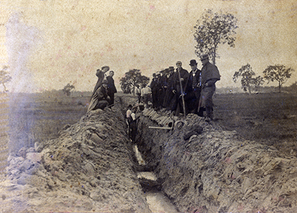 Draining the Orchard, 1892' - two men standing in trough, pipes, others standing on sides of trough, not workers - Cropped (Print 2 of 2) [Hawkesbury Agricultural College (HAC)]