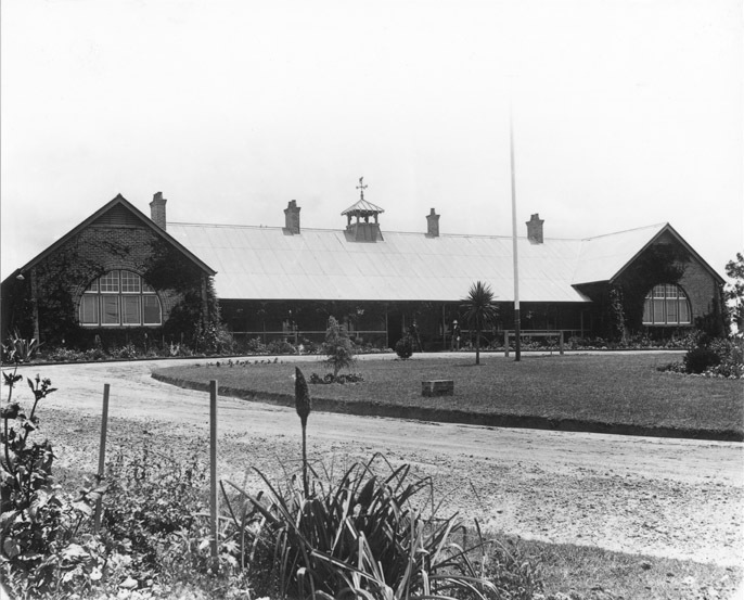 Main Administration Building - The first College building, with two men standing at the front entrance [Hawkesbury Agricultural College (HAC)]