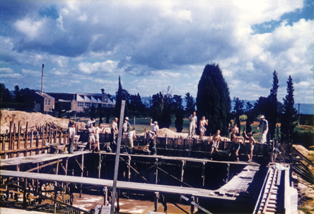 Olympic Swimming Pool - Construction (print 11 of 18) - Students and staff pouring concrete for the top section of wall at deep end of pool [Hawkesbury Agricultural College (HAC)]