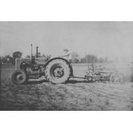 A tractor, driven by a student, towing farm machinery [Hawkesbury Agricultural College (HAC)]