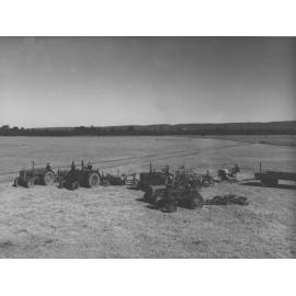 Tractors assembled in display in a paddock with horse teams in the background [Hawkesbury Agricultural College (HAC)]