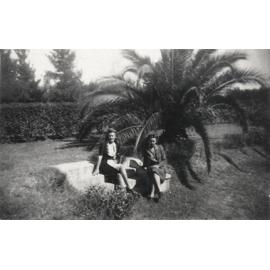 Women's Land Army: Faming activities (print 07 of 12) - Two women seated in front of a palm [Hawkesbury Agricultural College (HAC)]