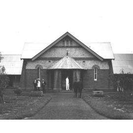 Quadrangle - Men standing outside the Dining Hall - the paths have been made and trees planted [Hawkesbury Agricultural College (HAC)]