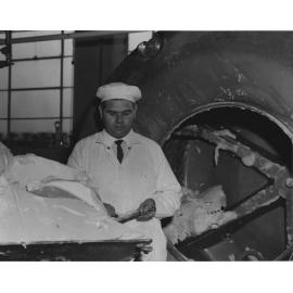 John Davis, instructor in butter making and ice-cream, standing by the machinery in the Dairy Factory [Hawkesbury Agricultural College (HAC)]