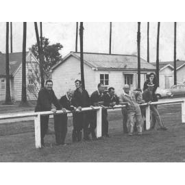 Staff members leaning on the fence near the oval [Hawkesbury Agricultural College (HAC)]