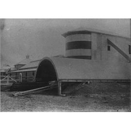 Twin silos with underground silo in foreground and dairy bails in background [Hawkesbury Agricultural College (HAC)]
