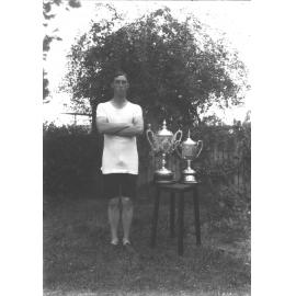 Student, G McGillivray, champion athlete, standing next to the trophies he won [Hawkesbury Agricultural College (HAC)]