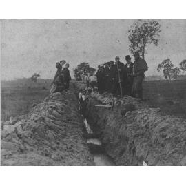 Draining the Orchard, 1892' - two men in trough, pipes, others standing on side of trough (not the workers) [Hawkesbury Agricultural College (HAC)]