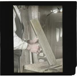 Man examining a wooden hand plane [Hawkesbury Agricultural College (HAC)]