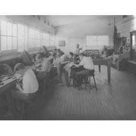 Saddlery Shop (interior) - Students seated at benches and two working a sewing machine [Hawkesbury Agricultural College (HAC)]